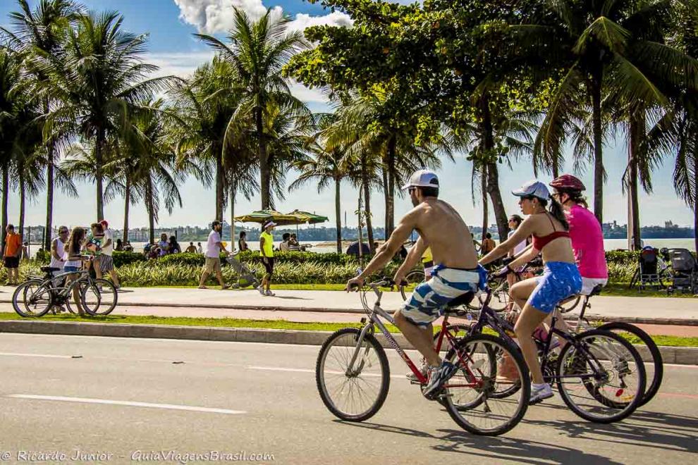 Imagem de três amigos de bicilceta na avenida da Praia de Cambori.